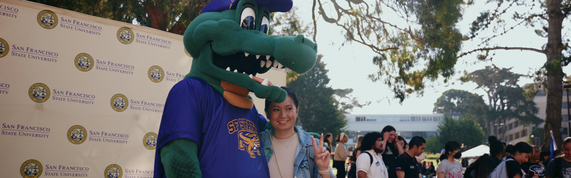 Mascot Alli Gator posing with a smiling student