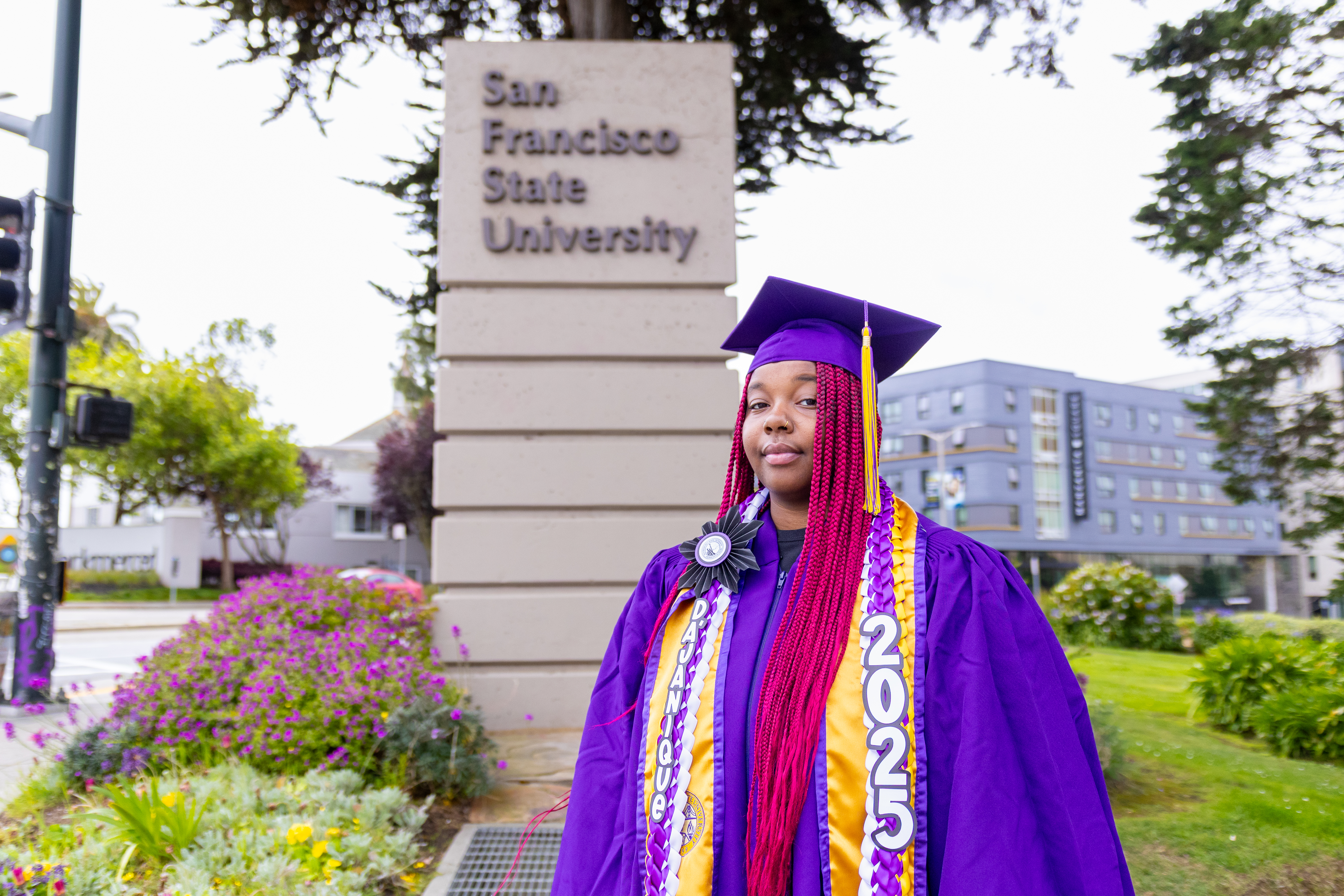 scholar in front of SFSU sign