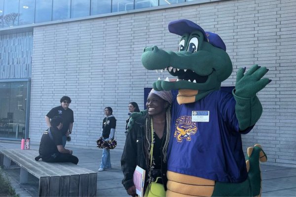 Ali Gator posing with a student