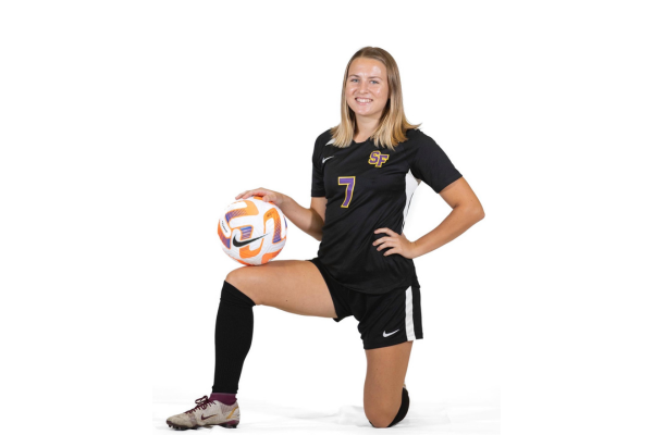 Kylie Schneider number 7, posing with soccer ball.