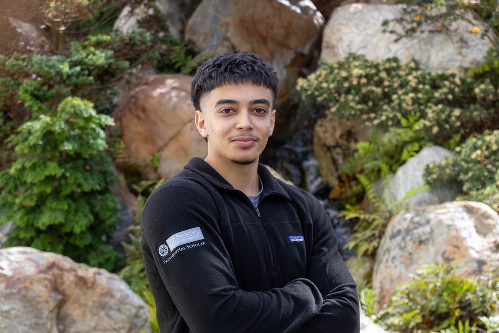 Male student who is a presidential scholar standing outside