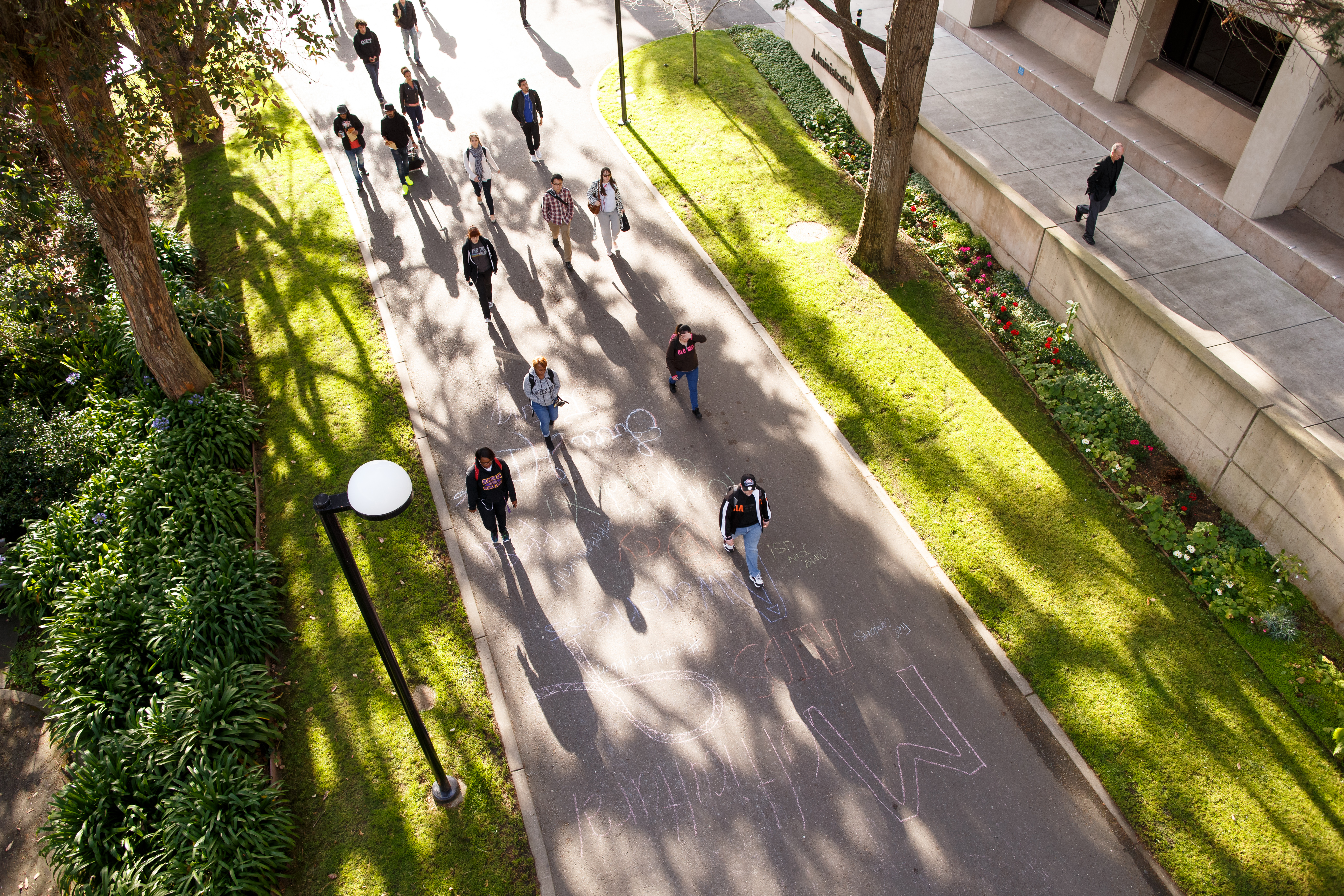 students walking on a main sidewalk through campus